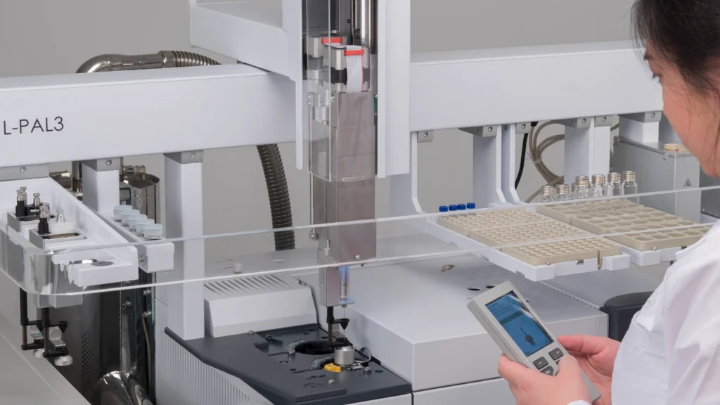 Químico haciendo ajustes al cargador automático de GC-MS