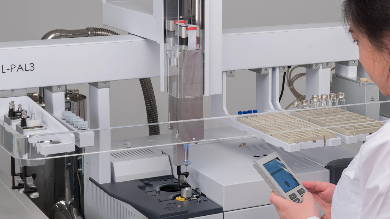 Químico haciendo ajustes al cargador automático de GC-MS