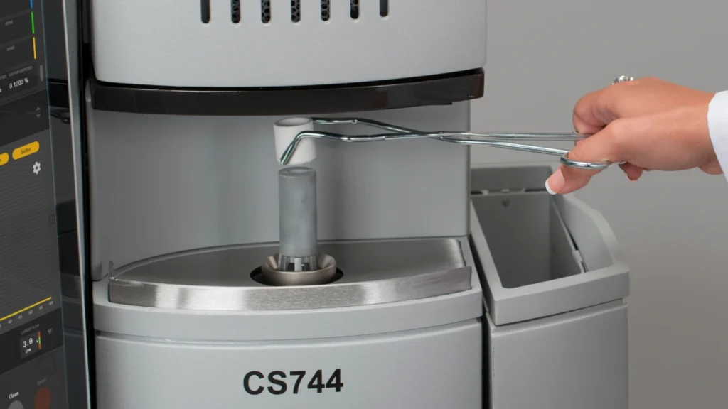 Scientist removing crucible from LECO CS744 carbon sulfur determination