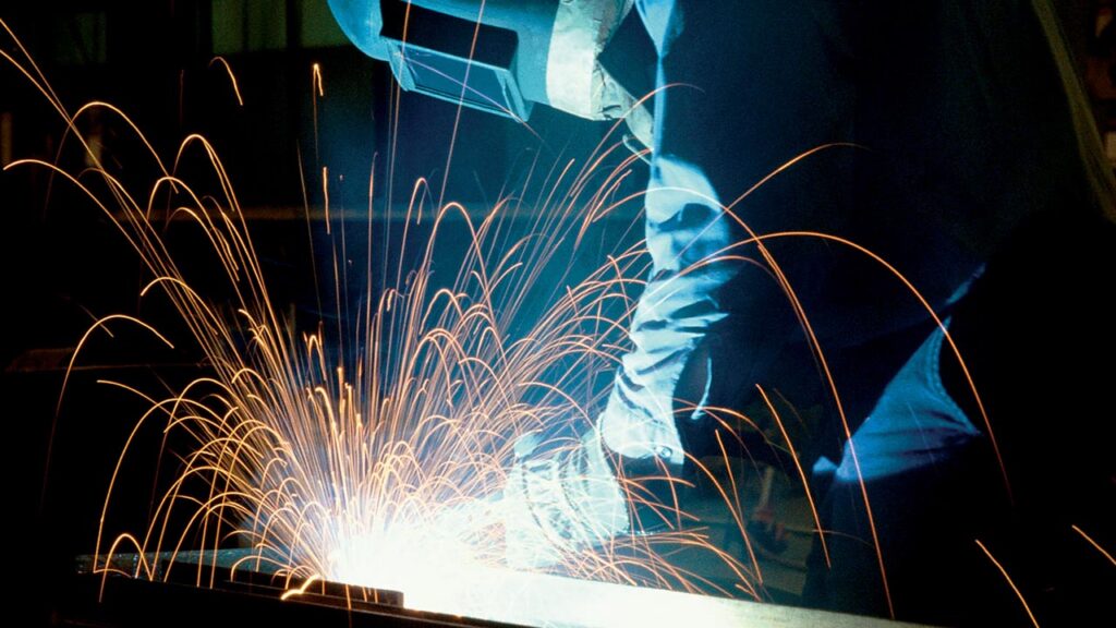 masked welder with sparks